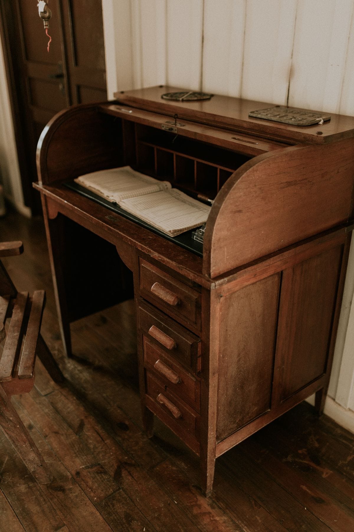 Vintage wooden roll-top desk in a rustic interior