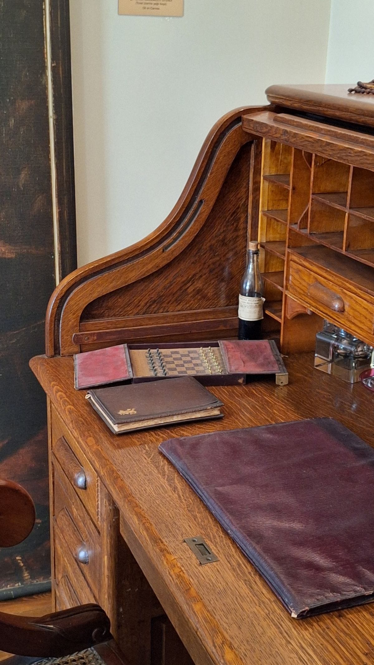 Vintage roll-top writing desk with papers and office supplies