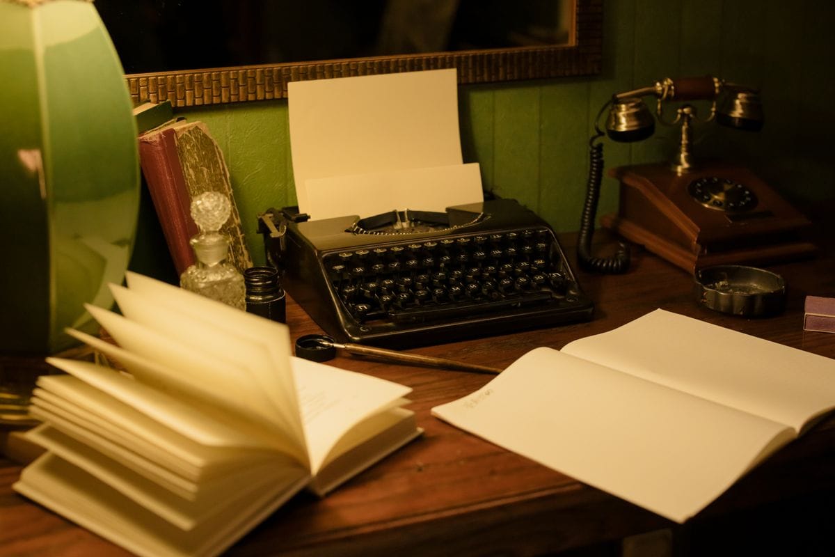 Vintage desk with typewriter, books and a retro lamp