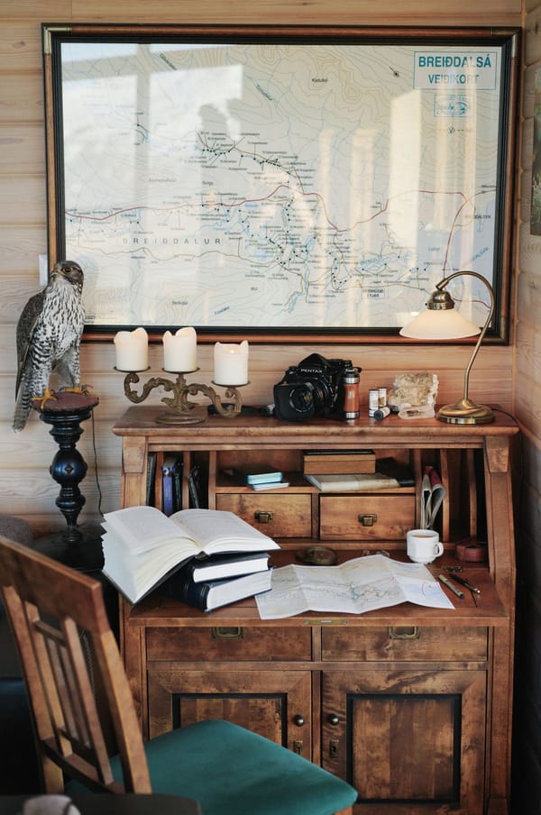 Rustic study with open books, a map and candles