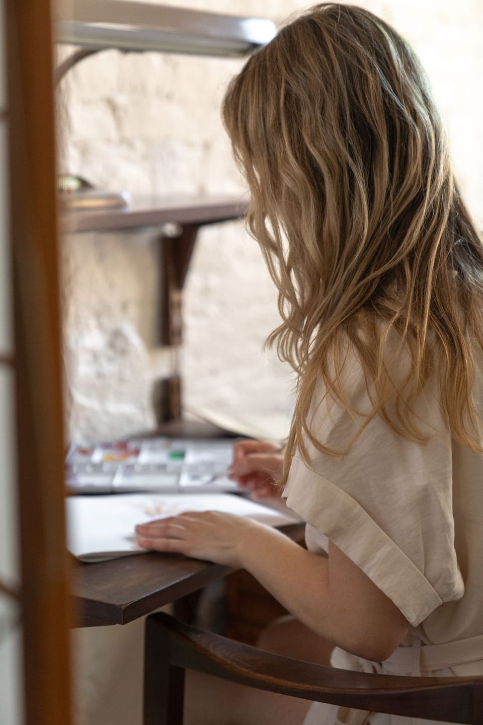 Writer seated at a desk making notes in a notebook